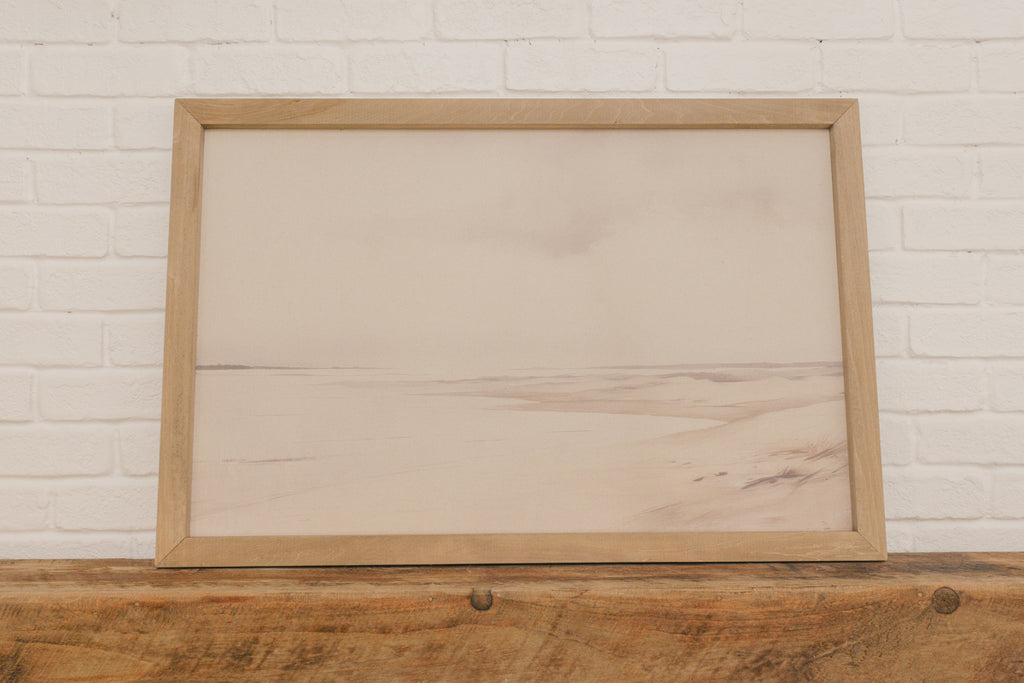 Wooden frame on a wooden surface with a white brick wall background