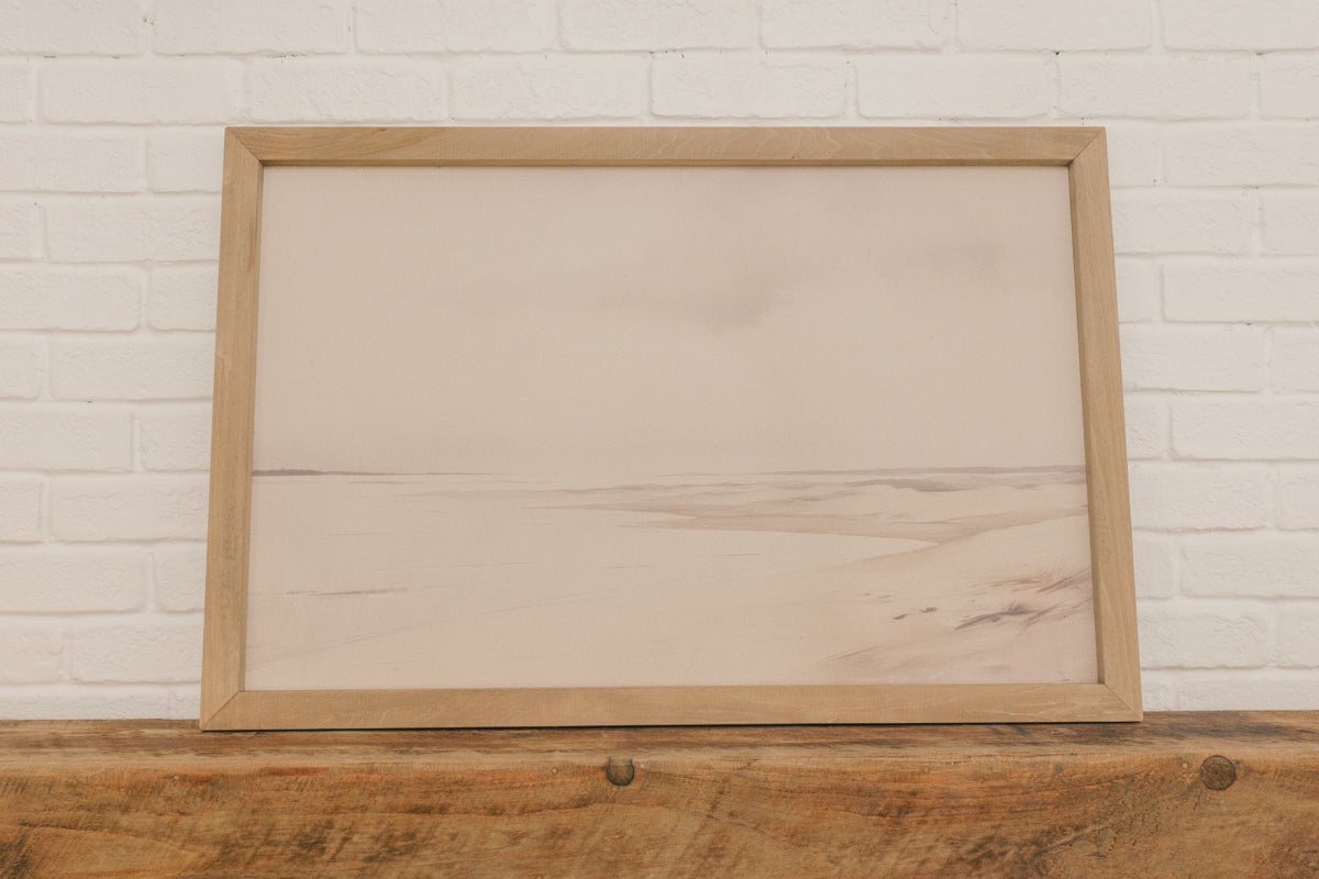 Wooden frame on a wooden surface with a white brick wall background